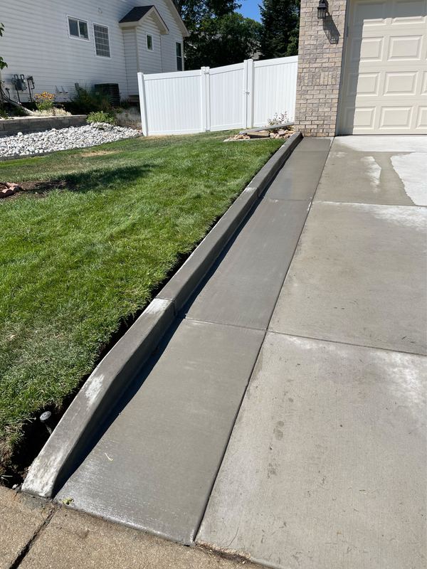 Concrete drainage strip poured along the low edge of a driveway